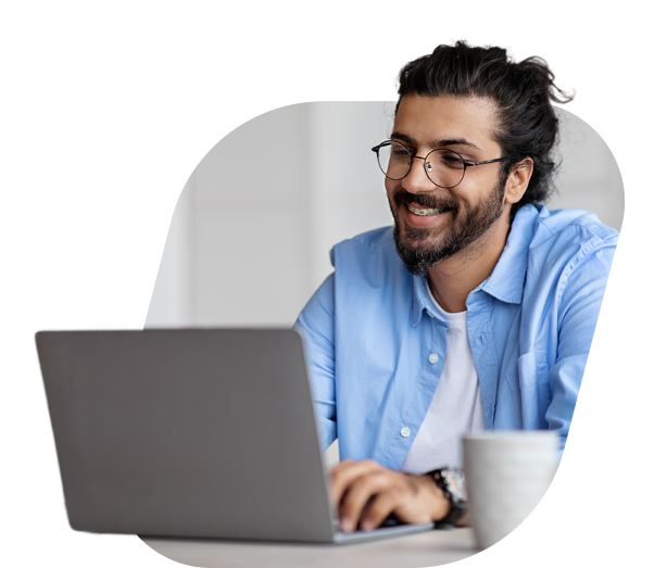 Homem com óculos utilizando um notebook e sorrindo